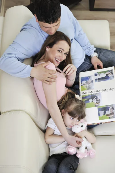 Glückliche Familie sucht Fotos zu Hause — Stockfoto