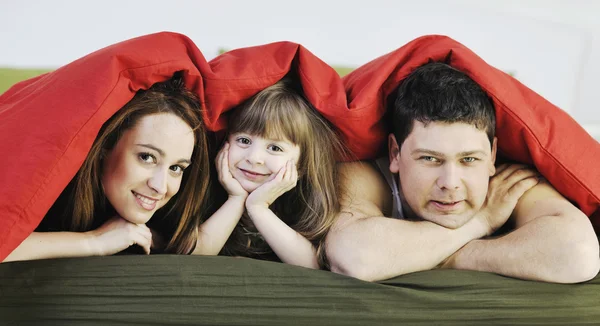 Happy family relaxing in bed — Stock Photo, Image