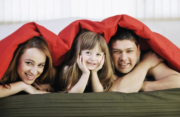 Familia feliz relajarse en la cama — Foto de Stock