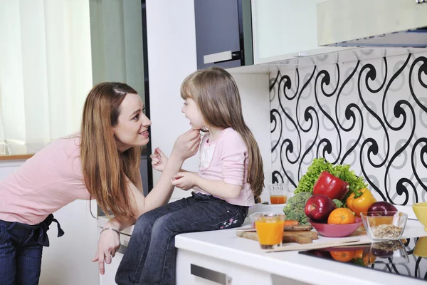 Счастливая дочь и мама на кухне — стоковое фото