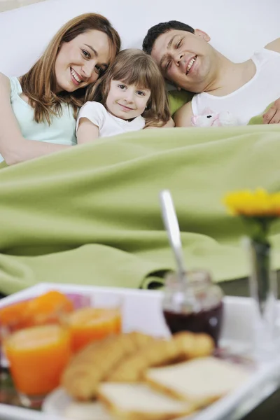 Gelukkig jong gezin ontbijten in bed — Stockfoto