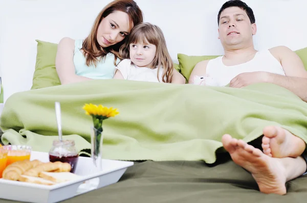 Feliz familia joven desayunar en la cama —  Fotos de Stock