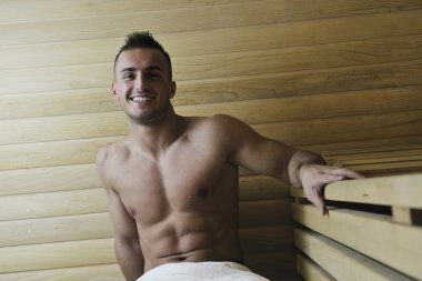 Attractive young man in sauna clipart