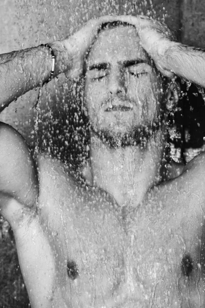 Красивый мужчина под мужским душем — стоковое фото
