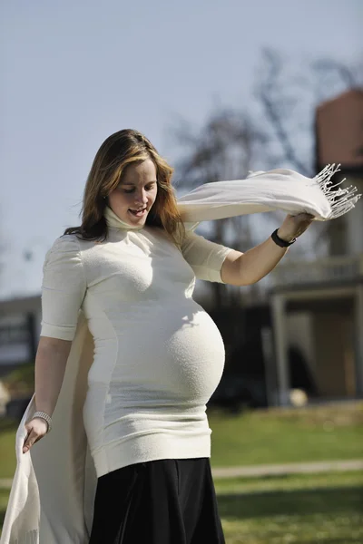 Счастливая молодая беременная женщина на открытом воздухе — стоковое фото