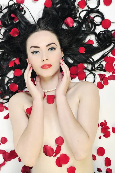 Piękna młoda kobieta nago z róż na białym tle — Zdjęcie stockowe