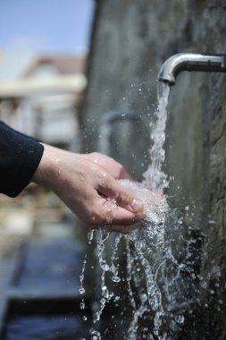 Fresh mountain water falling on hands clipart