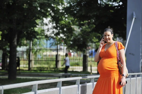 Счастливая беременная женщина разговаривает по мобильному телефону — стоковое фото