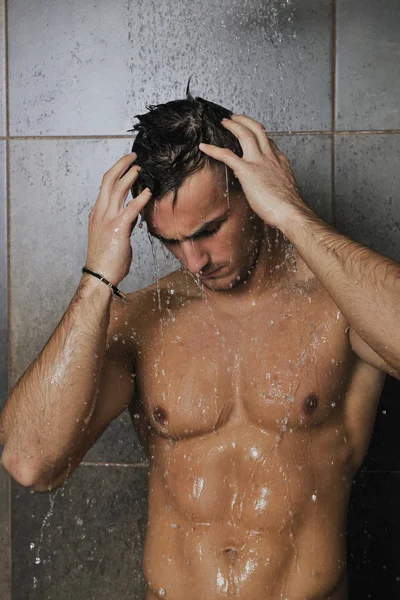 Homem bonito sob o chuveiro do homem — Fotografia de Stock
