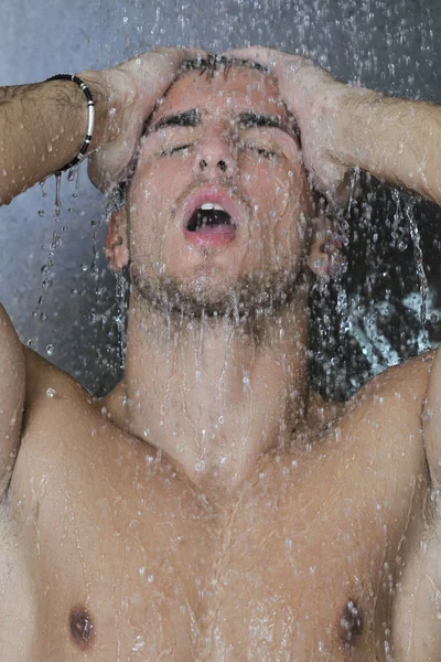 Homem bonito sob o chuveiro do homem — Fotografia de Stock