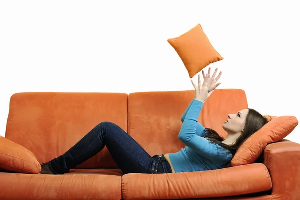 Mujer joven relajarse en sofá naranja — Foto de Stock