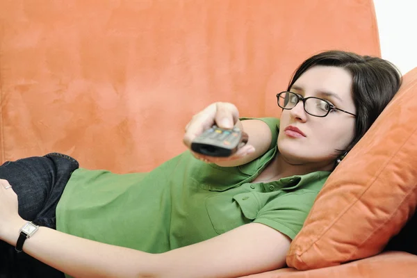 Молодая женщина отдыхает на оранжевом диване — стоковое фото