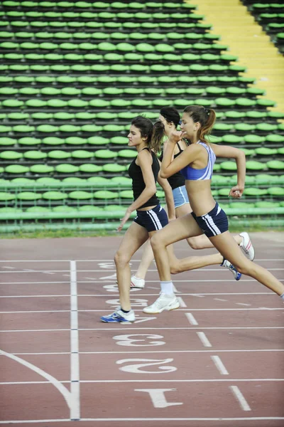 Chicas corriendo en pista de atletismo — Foto de Stock