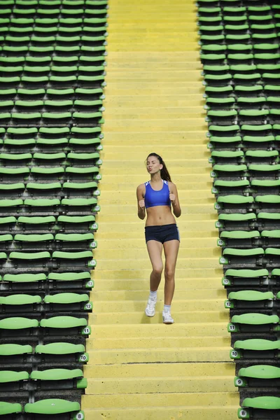 Vrouw joggen op atletiek stadion — Stockfoto