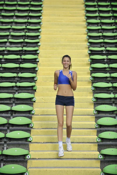 Mujer corriendo en el estadio de atletismo — Foto de Stock