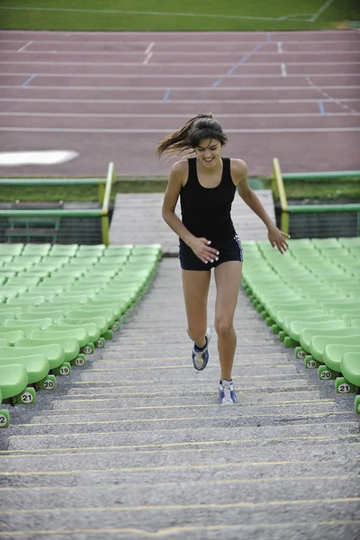 Mujer corriendo en el estadio de atletismo —  Fotos de Stock