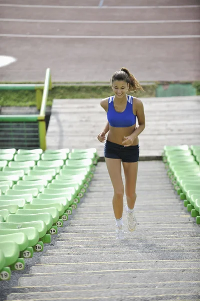Kvinna jogging på friidrott stadium — Stockfoto
