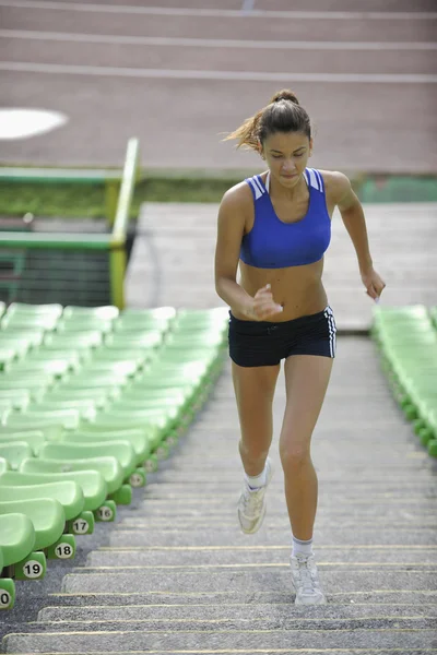Vrouw joggen op atletiek stadion — Stockfoto
