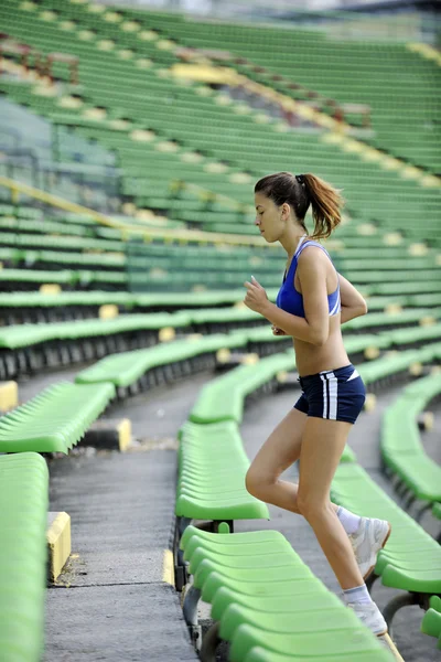 Mujer corriendo en el estadio de atletismo —  Fotos de Stock
