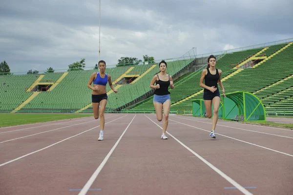 Chicas corriendo en pista de atletismo — Foto de Stock