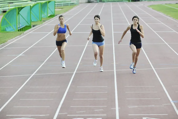 Meninas correndo na pista de atletismo — Fotografia de Stock