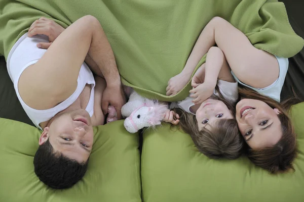 Ευτυχισμένη οικογένεια χαλαρώνοντας στο κρεβάτι — Φωτογραφία Αρχείου