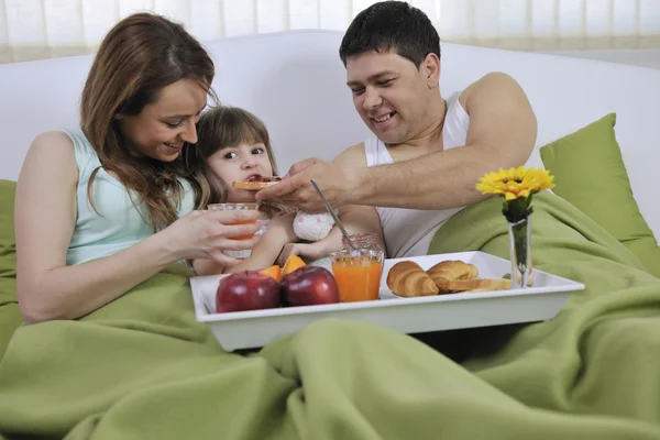 Lycklig familj avkopplande i sängen — Stockfoto