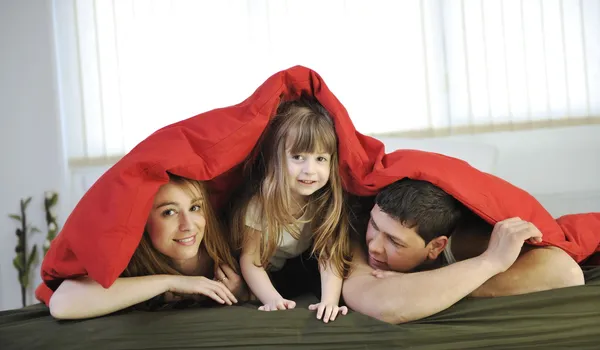 Щаслива сім'я розслабляється в ліжку — стокове фото