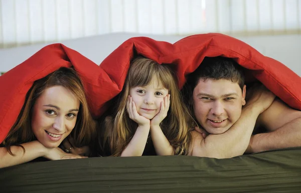 Familia feliz relajarse en la cama —  Fotos de Stock