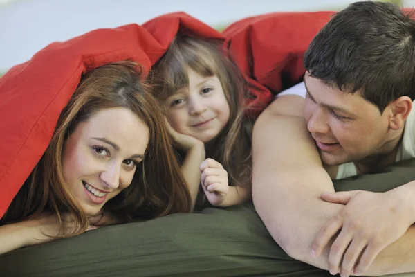 Ontspannen in bed en gelukkige familie — Stockfoto