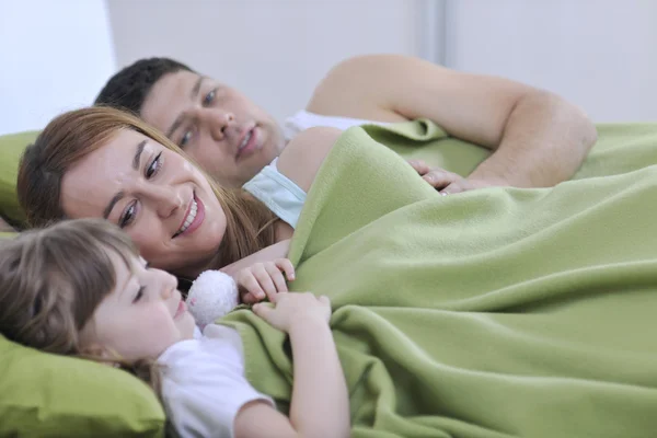 幸福的家庭放松躺在床上 — 图库照片