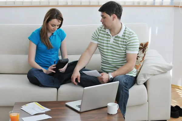 Giovane coppia che lavora su laptop a casa — Foto Stock