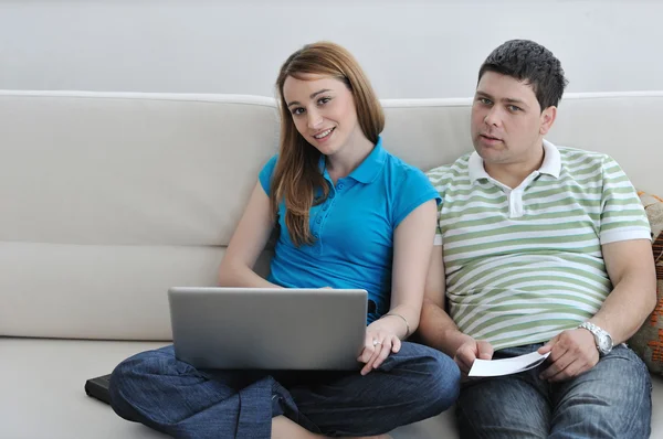 Jovem casal trabalhando no laptop em casa — Fotografia de Stock