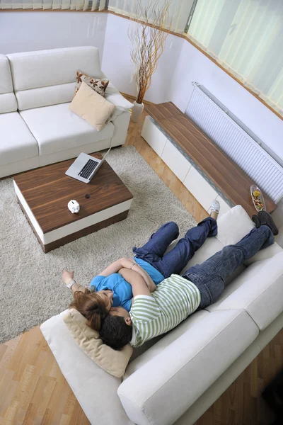 Pár odpočívat doma na pohovce v obývacím pokoji — Stock fotografie