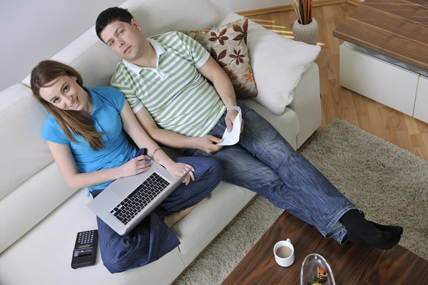 Jovem casal trabalhando no laptop em casa — Fotografia de Stock