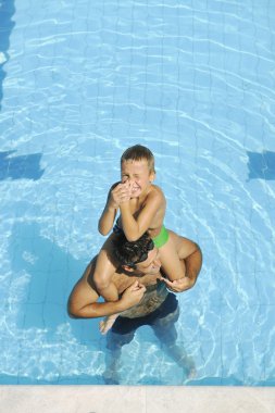 Mutlu genç aile yüzme havuzunda iyi eğlenceler.