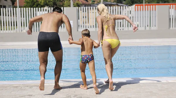 Feliz jovem família se divertir na piscina — Fotografia de Stock