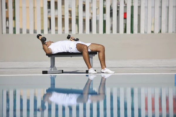 Jong gezond atleet man oefening aan het zwembad — Stockfoto
