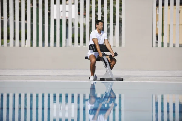 Young healthy athlete man exercise at poolside — Stock Photo, Image