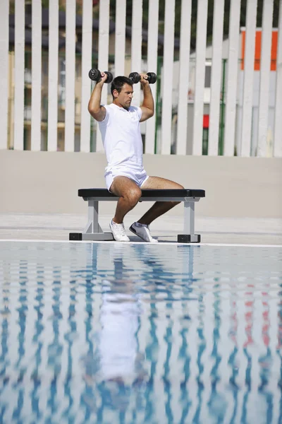 Fiatal egészséges sportoló férfi testmozgás a medence mellett — Stock Fotó