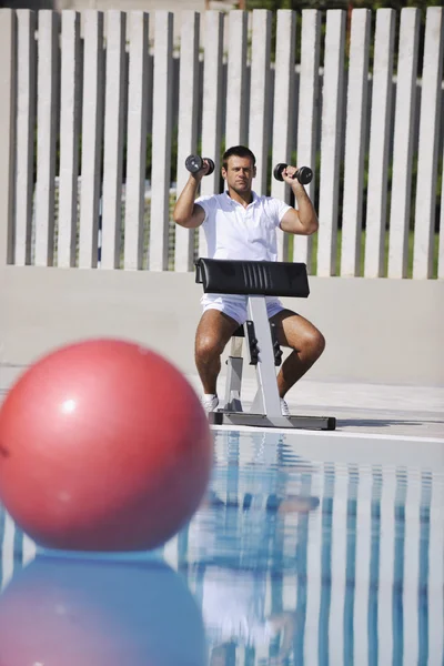 Nuori terve urheilija mies liikunta altaalla — kuvapankkivalokuva