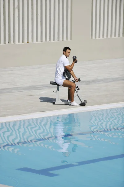 Fiatal egészséges sportoló férfi testmozgás a medence mellett — Stock Fotó