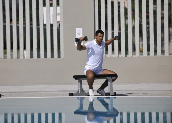 Nuori terve urheilija mies liikunta altaalla — kuvapankkivalokuva