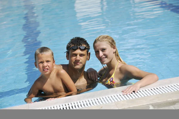 Feliz jovem família se divertir na piscina — Fotografia de Stock