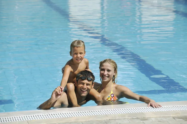 Χαρούμενη νεαρή οικογένεια διασκεδάστε στην πισίνα — Φωτογραφία Αρχείου