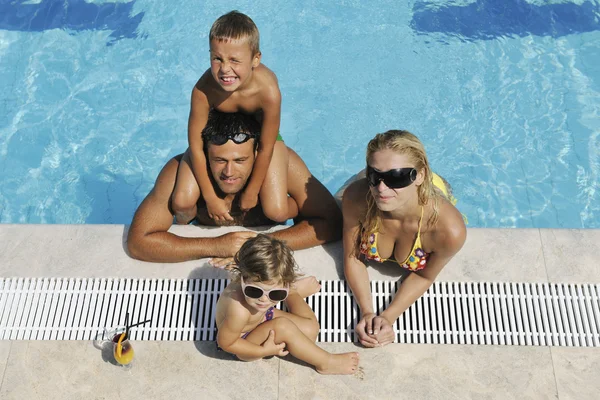 Щаслива молода сім'я розважається на басейні — стокове фото
