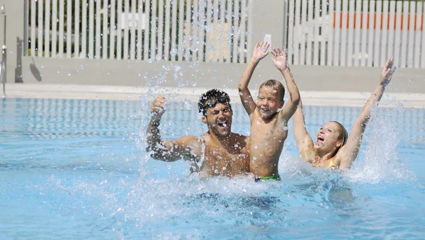 Feliz familia joven divertirse en la piscina —  Fotos de Stock