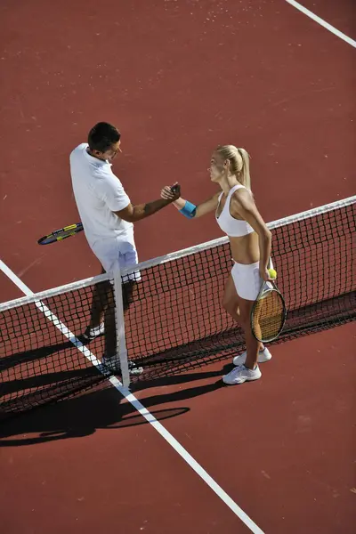 Feliz jovem casal jogar tênis jogo ao ar livre — Fotografia de Stock