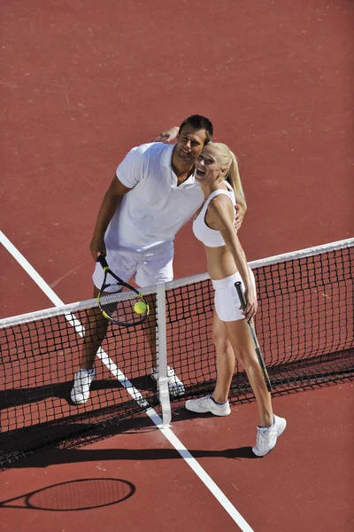 Счастливая молодая пара играть в теннис на открытом воздухе — стоковое фото