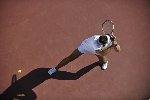 Молодий чоловік грає в теніс на відкритому повітрі — стокове фото